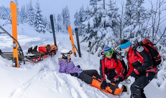 Ski patrol team rescue woman skier with broken leg